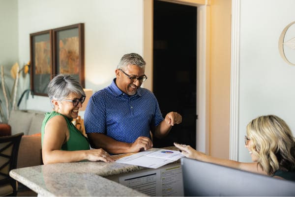 a couple smiling during their wealth management consultation